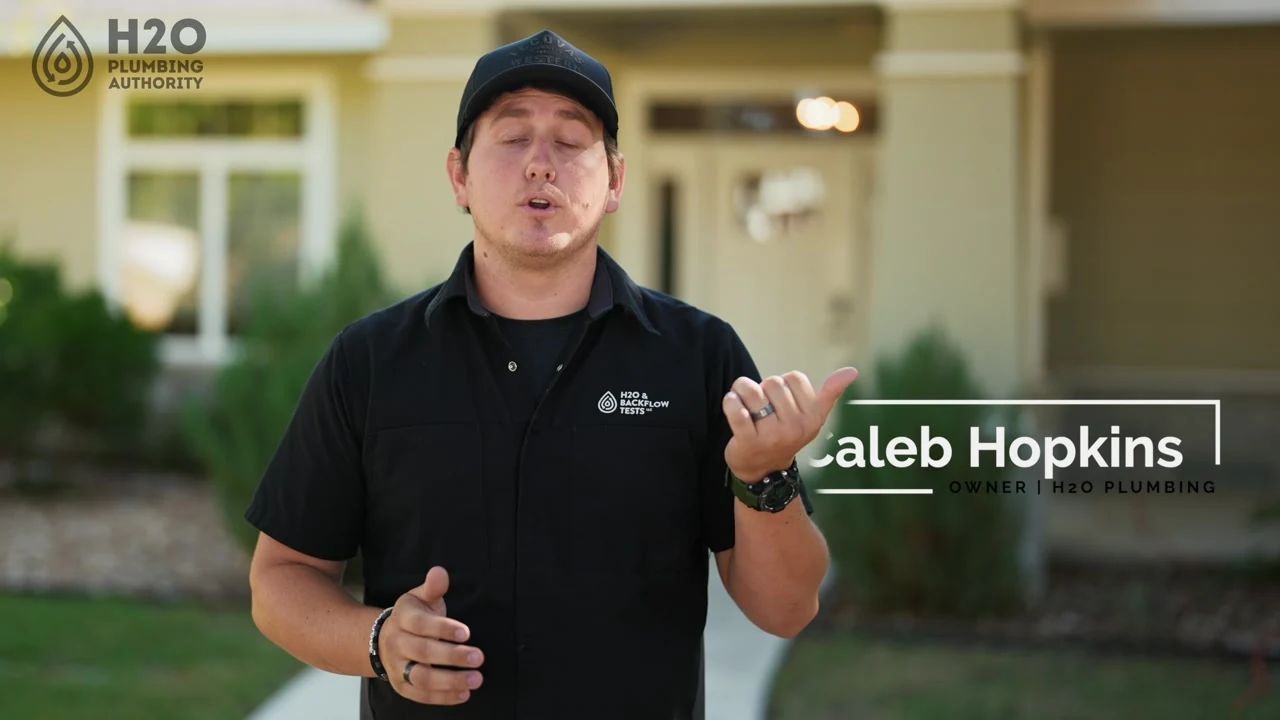 H2O Plumbing Authority team member standing outside a home