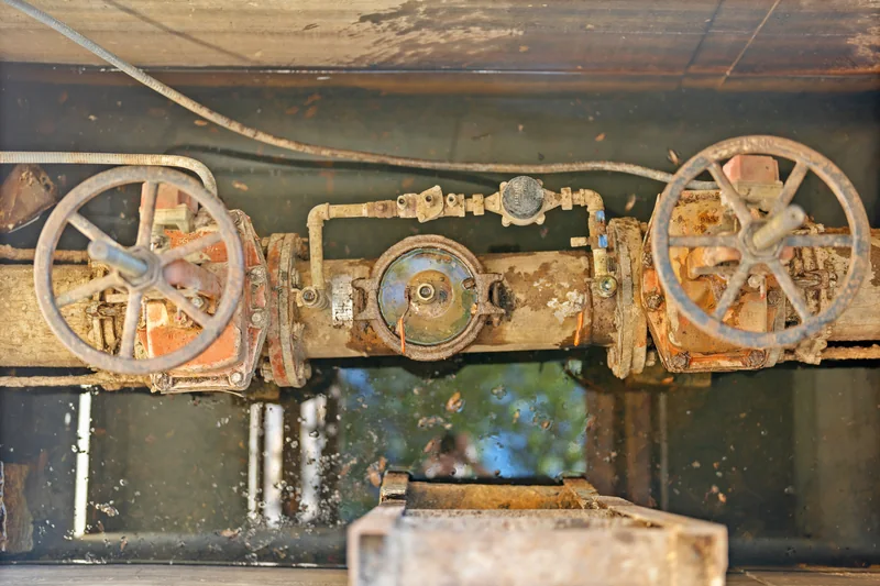 Large valve wheels and connected piping inside an open commercial utility vault