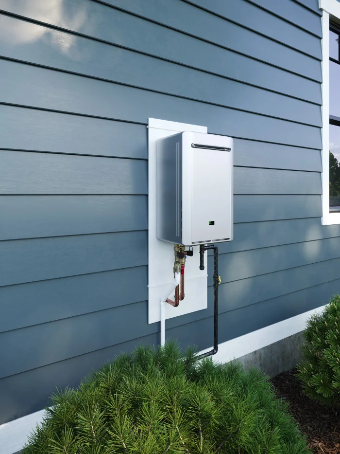 Exterior tankless water heater mounted on blue siding, with visible connections below